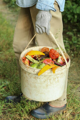 Zero waste, composting, bio waste concept. Farmer with vegetable and fruit food scraps and grass in...