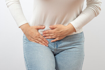 Woman holding lower abdomen from side. Pain or spasm. Gynecological problems or appendicitis