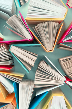 Book background. Many colorful books create texture for design. Concept of library, children's literature, textbooks for teenagers.