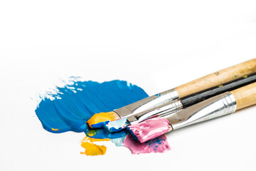 Old brushes with thick paints, acrylic or oil