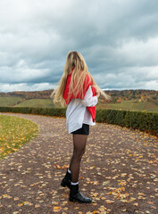 Blonde woman rear view in an autumn scenery