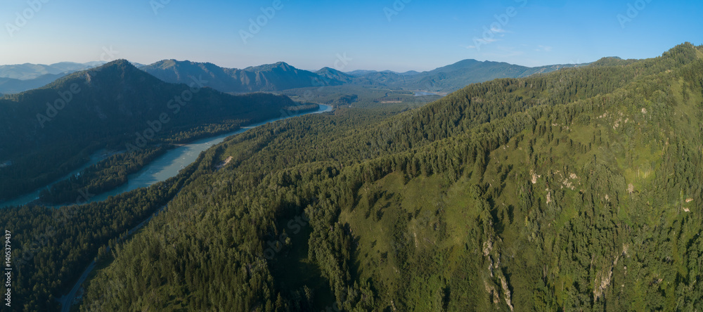 Aufkleber Mountain range with a river flowing through it. The river is green and clean. The mountains are covered with trees. A view from above with a drone