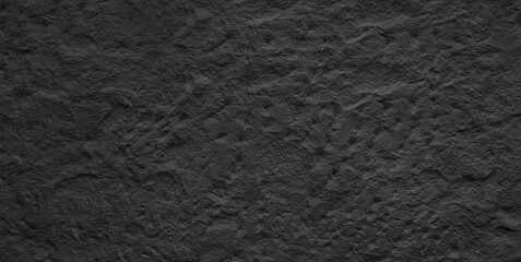 A dark black , textured background that is almost entirely black. The surface of the background is rough and uneven, giving it a rugged appearance.