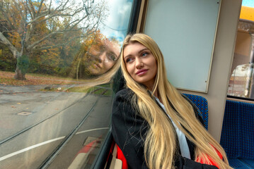 Smiling woman and reflection in window on public transportation in Stuttgart