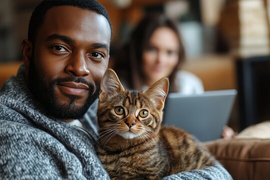 Man cuddling tabby cat on sofa, relaxed home, cozy atmosphere.