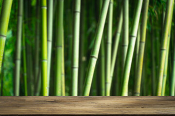 Bamboo forest table. Empty wooden table for product display on green bamboo forest background