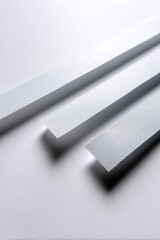 Strips of adhesive tape laid out on a pristine white background, highlighting their surface feel.