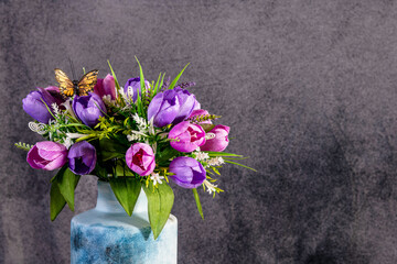 Colorful tulip bouquet with butterfly isolated on grey background with room for copy