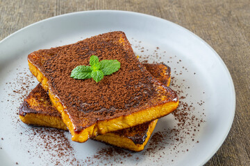 choco lava french toast, toasted bread topped with melted chocolate and cocoa powder