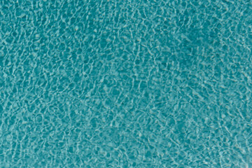 Swimming pool with clear blue water with sunlight shadow reflections. Minimalistic aesthetic summer...