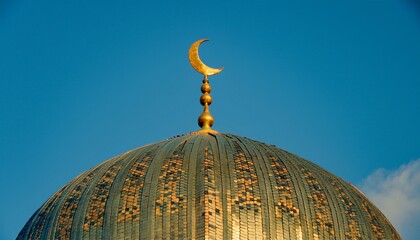 Golden mosque dome with crescent moon against blue sky in afternoon light