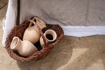 On the floor is a basket with earthenware vases from the Roman Empire. The vases are of different...