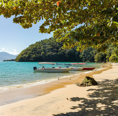 Taxi boat anchored at Abraãozinho Beach with taxi boat and blue waters in Abraão, on tropical...