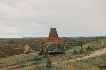 A Wooden Shack or Hut with several statue on Palindi Piarakuku Hills, East Sumba, Indonesia. 