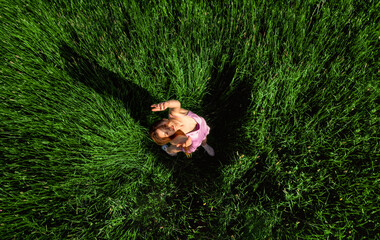 Aerial view with a woman enjoying nature in a grass field