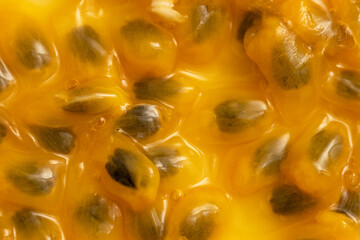 A close up of a yellow fruit with black seeds