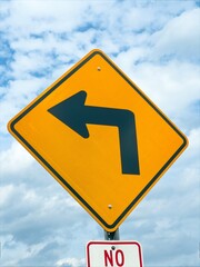 Left turn arrow traffic sign in front of a cloudy saky