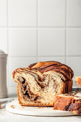 Chocolate Babka or Brioche loaf Bread sliced on white kitchen background. Homemade sweet yeast pastry for easter, text space