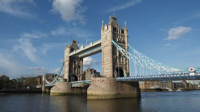 Tower Bridge. Timelapse of Tower bridge in London stands majestically under blue sky. Red double deck bus on London bridge river Thames England. Iconic landmark historic architecture modern urban life