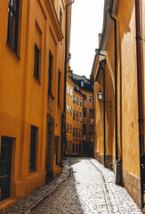 narrow street in stockholm with people walking by in spring sunny