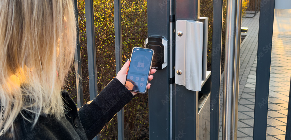 Poster woman locking smartlock on the entrance door using a smart phone. concept of using smart electronic 