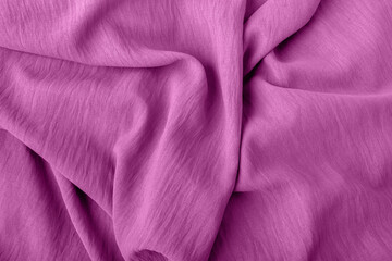 Elegant fabric texture in soft pink color with soft flowing folds and creases