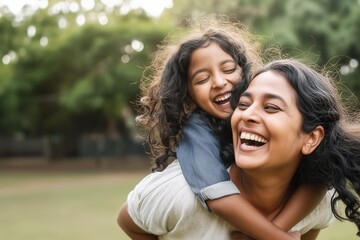 Naklejka premium Happy indian mother having fun with her daughter outdoor - Family people and love concept - Focus on mum face