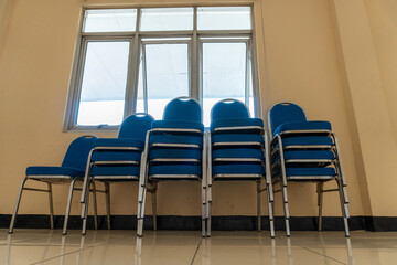 Stacked Blue Chairs with Metal Frame Near Window Inside Room