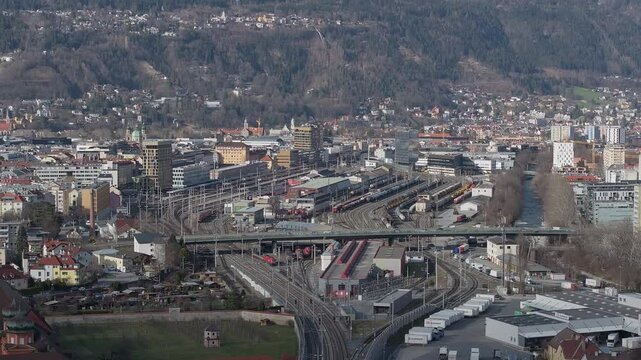 Aerial view of the Bergisel Ski Jump in Innsbruck, Austria, with gradual motion showcasing its modern design and the surrounding snow capped Alps.
