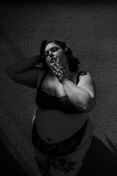 old hollywood plus size model wearing lingerie dramatic lighting