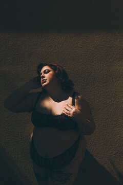 old hollywood plus size model wearing lingerie dramatic lighting