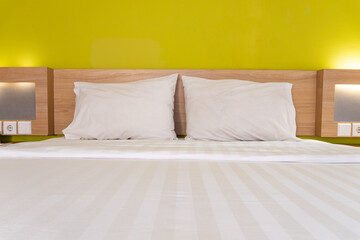 Hotel Bedroom Featuring Clean Bed with Pillows and Green Headboard