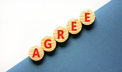 Agree symbol. Concept word Agree on beautiful wooden circles. Beautiful white and blue background....