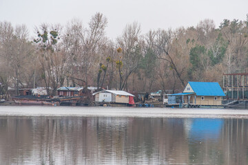 Image of a calm, serene water body with colorful homes or shelters along the shore Background features lush green landscape Conveys tranquility and harmony with nature - Kyiv, Ukraine, 09-15-2024