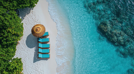 Tropical white sand beach meeting turquoise water with sunbeds and parasol