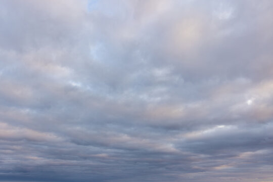 Photo of beautiful cloudscape light blue pink and gray fluffy clouds covering the sky