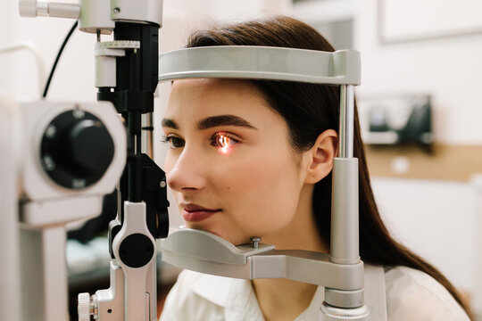 Ophthalmology procedure with slit lamp for eye and cornea checkup. Girl is visiting ophthalmologist for eyes examination.