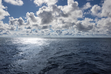 Bright sun reflecting on the Atlantic Ocean surface gorgeous horizon and appealing cloudscape.