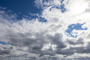Appealing cloudscape white and grayish fluffy Cumulus clouds blue sky peeking through.