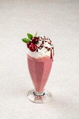Glass of sweet fresh cherry milkshake with mint