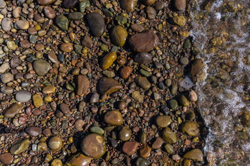 Pebbles and rocks on the shoreline background photograph.
