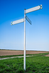 white road sign with three plates indicating directions in different directions