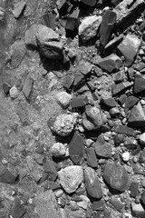 Black and white vertical close of photograph of background texture jagged rocky shoreline