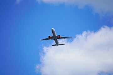 Fototapeta premium Airplane Flying Above Fluffy Clouds