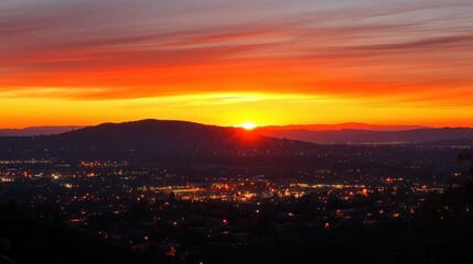 Obraz premium Vibrant sunset over city, hills, landscape