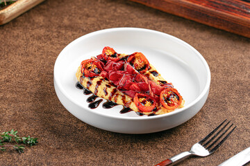 Portion of gourmet hummus with bresaola and sun-dried tomatoes