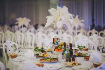 Elegant banquet table adorned with fine dining arrangements and exquisite floral centerpieces in a lavish event setting during festivities.