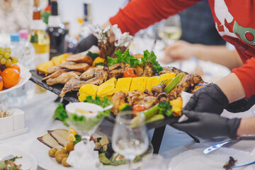 Delicious array of grilled meats and vibrant garnishes served at a festive gathering filled with joy and laughter. Waiter serving table in the restaurant preparing to receive guests.
