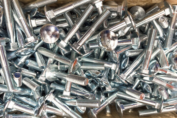Closeup view of assorted metal screws and bolts in workshop storage container