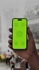 GREEN SCREEN CHROMA KEY Person holding a smartphone in a futuristic indoor garden with a large waterfall in the background, blending technology and nature